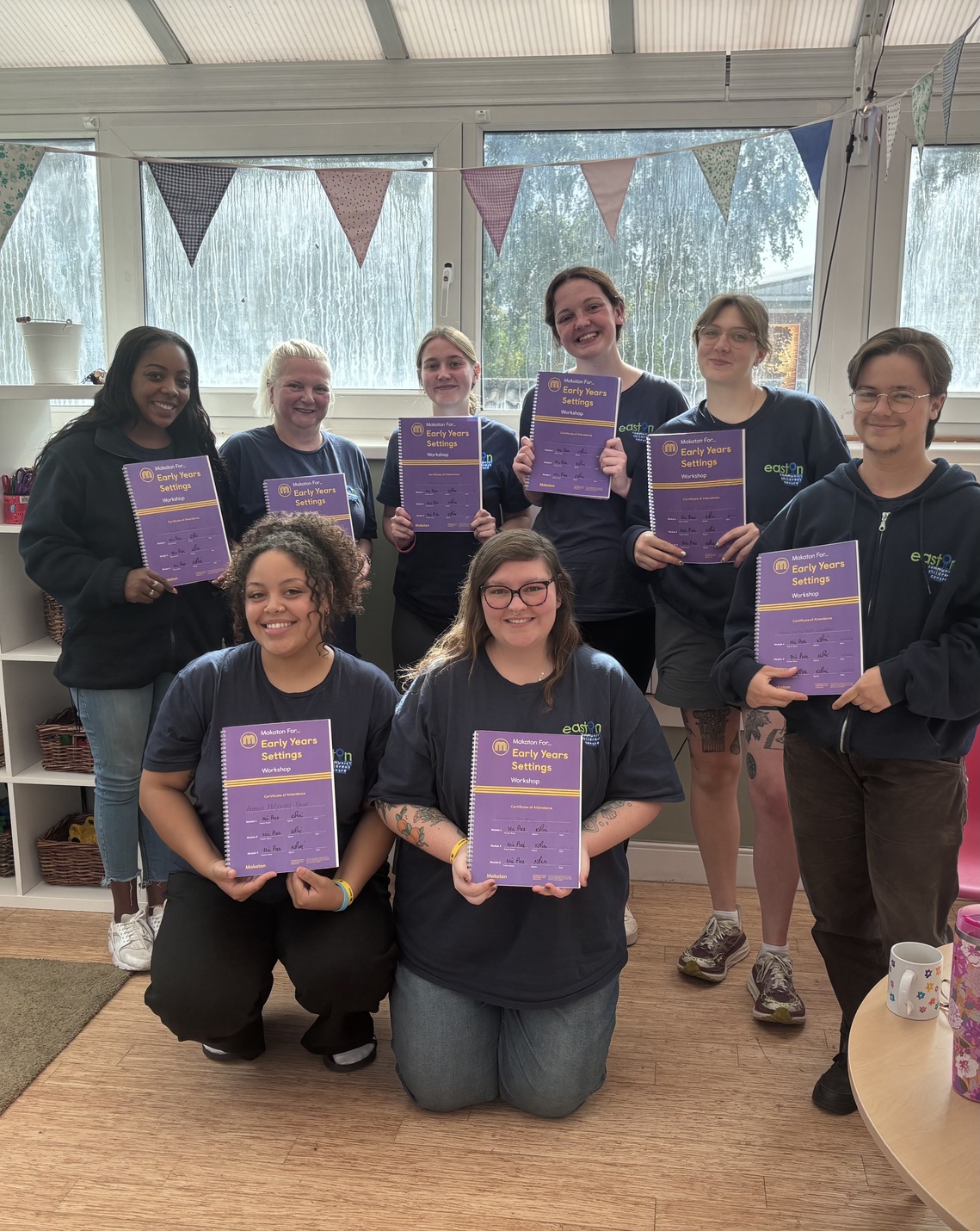 Group of learners holding up a Makaton For... Early Years Settings certificate of attendance