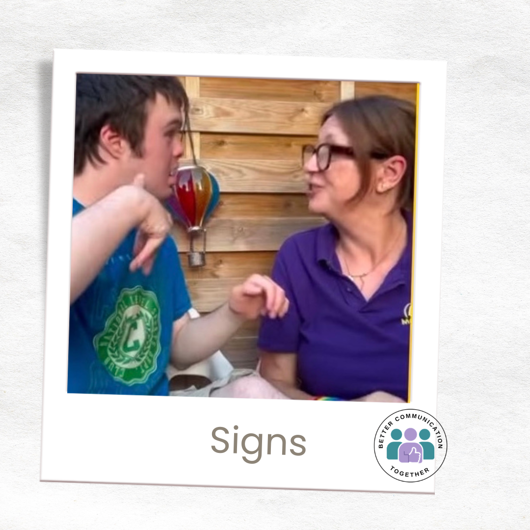 Two people communicating together using Makaton signs.
